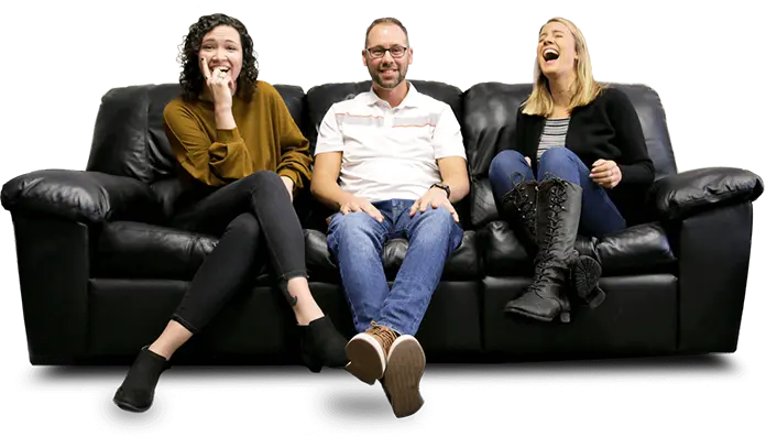 Three Mainstreethot team members sitting on a couch smiling